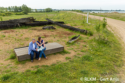 Foto toont twee mensen op een bank die geniete van het landschap